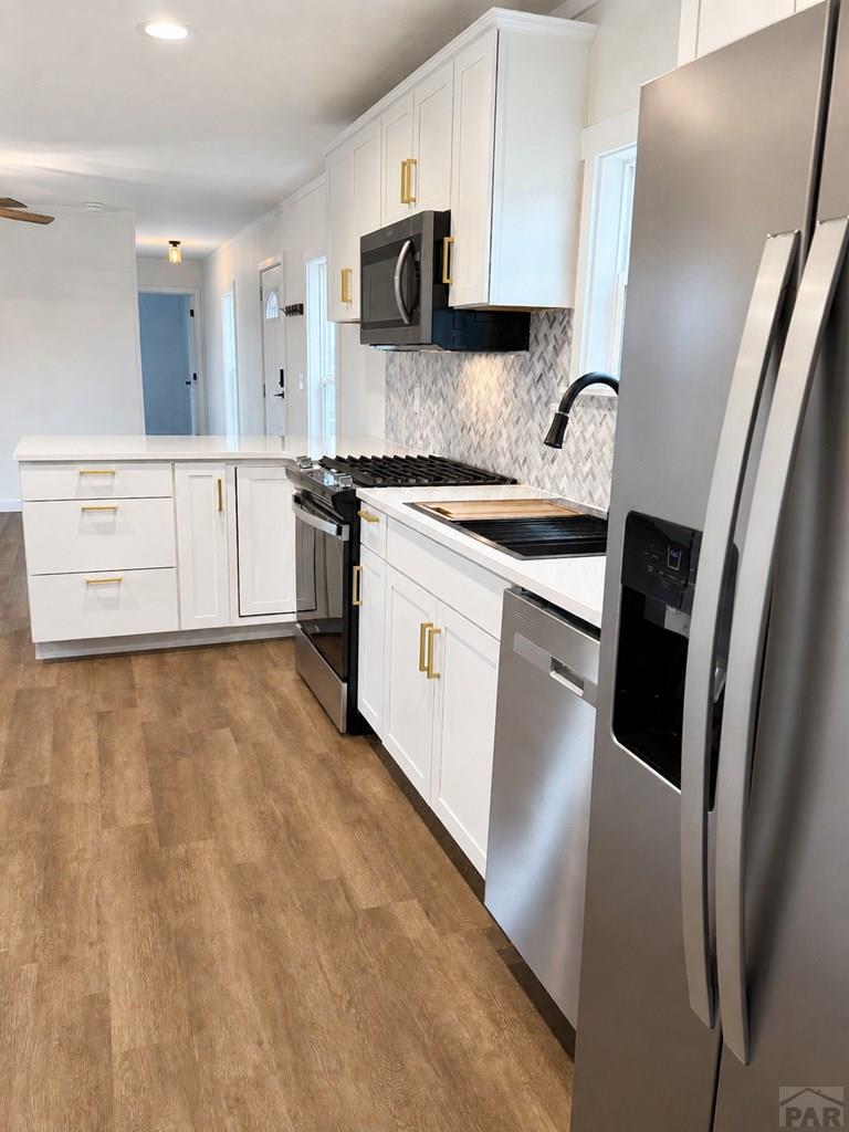 6652 County Rd HH.5 Lamar, CO 81052 - Photo 6 of 22 a kitchen with stainless steel appliances a refrigerator sink and white cabinets