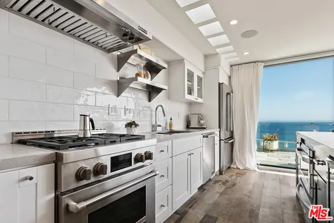 a kitchen with stainless steel appliances a stove a sink and a refrigerator