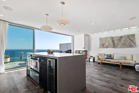 a kitchen with a stove and wooden floor