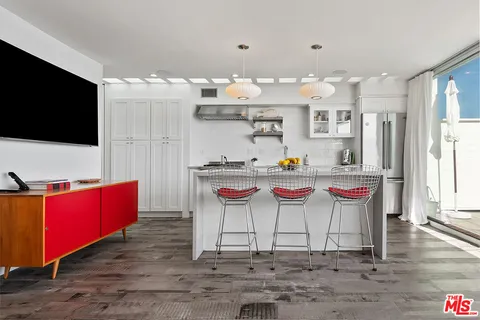a living room with kitchen island furniture and a flat screen tv