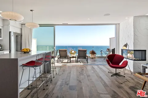 a living room with furniture a dining table and a chandelier