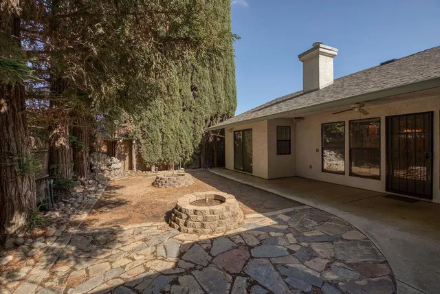 a patio with a table and chairs and potted plants