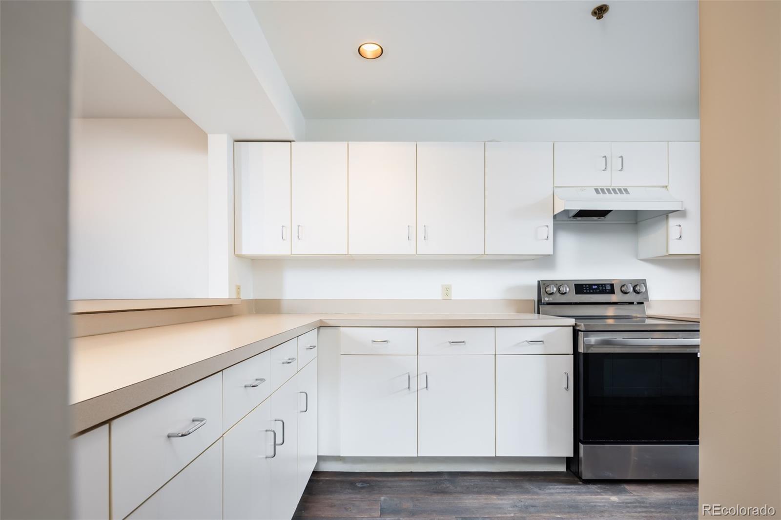 930 Acoma Street, Unit 212 Denver, CO 80204 - Photo 12 of 35 a kitchen with white cabinets stainless steel appliances and sink