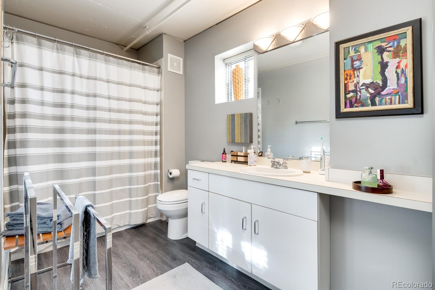 930 Acoma Street, Unit 212 Denver, CO 80204 - Photo 26 of 35 a bathroom with a double vanity sink toilet and a mirror