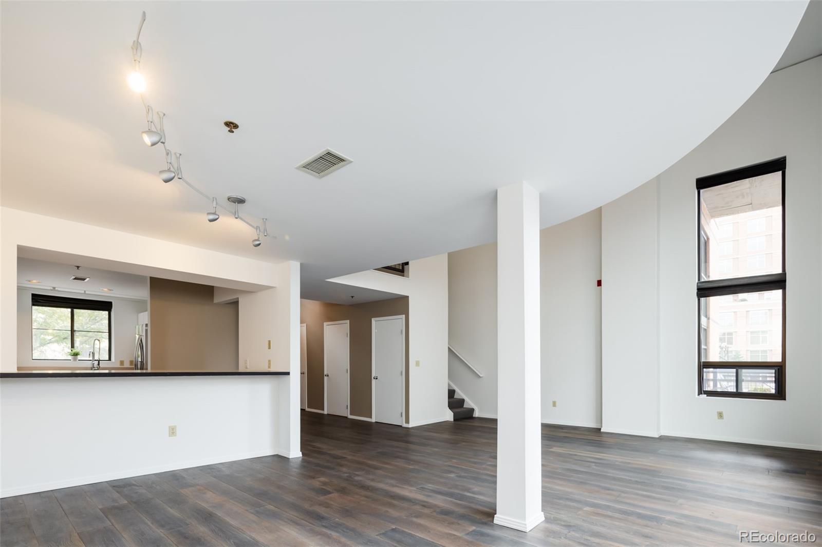 930 Acoma Street, Unit 212 Denver, CO 80204 - Photo 9 of 35 an empty room with wooden floor and windows