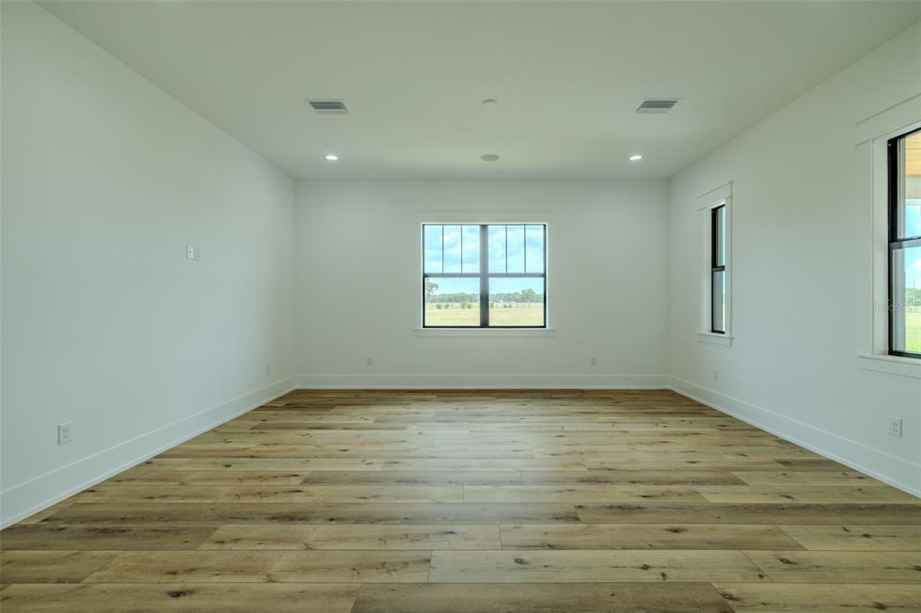 3515 Powerline Road Lithia, FL 33547 - Photo 65 of 100 a view of an empty room with wooden floor and a window