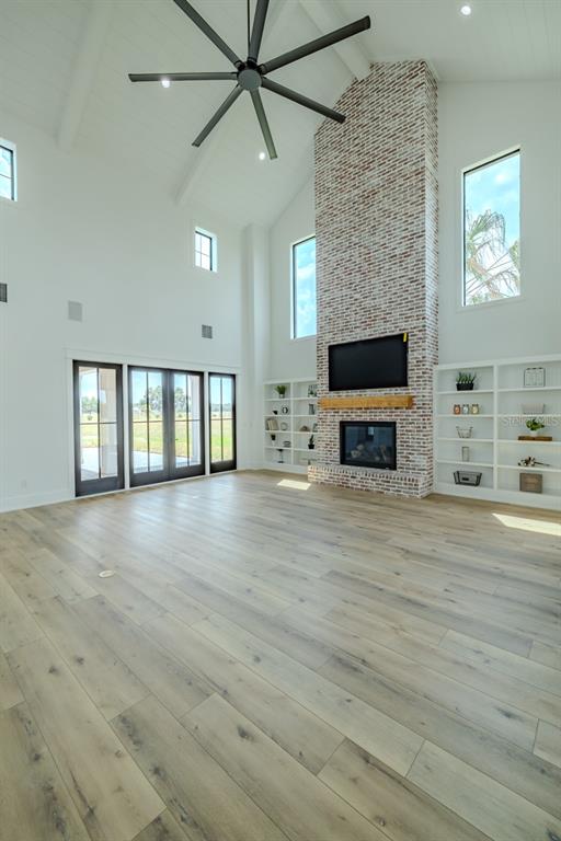 3515 Powerline Road Lithia, FL 33547 - Photo 82 of 100 an empty room with fireplace wooden floor and windows