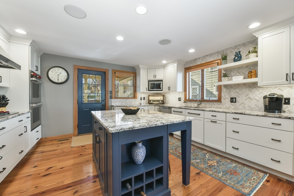 a kitchen with granite countertop cabinets a stove a sink and a window