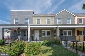 2002 E Street Northeast Washington, DC 20002 - Photo 2 of 13 a view of a white house with large windows and a table and chairs in a yard