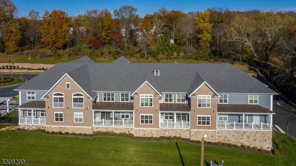 a aerial view of residential houses with yard and trees in the background