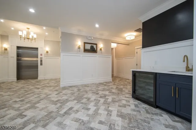 a view of an empty room and kitchen space with a sink