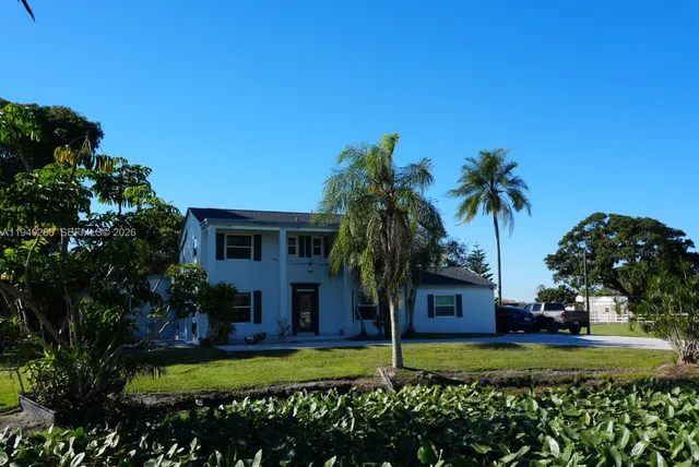 a view of a house with a yard and swimming pool