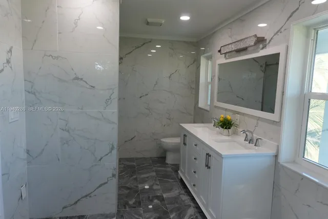a bathroom with a double vanity sink toilet and shower