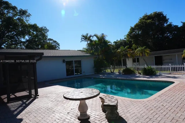 a view of a house with swimming pool and furniture