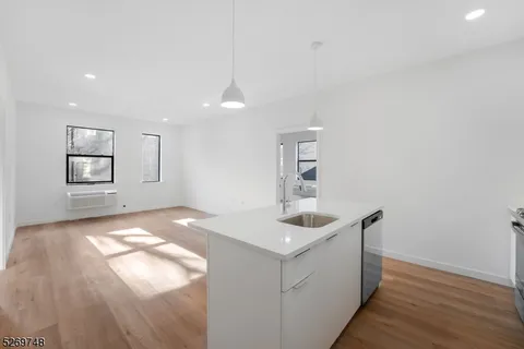 a kitchen with granite countertop a sink and dishwasher with wooden floor