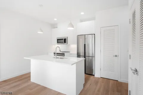 a view of a bedroom with a bed and white walls
