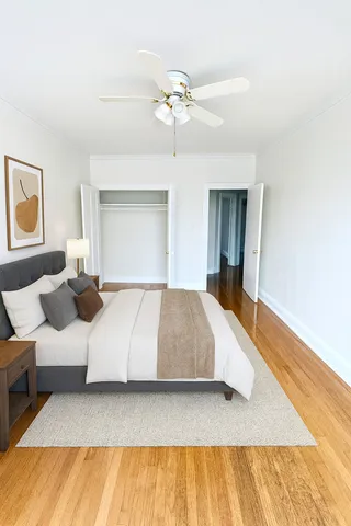 a bedroom with a large bed and a ceiling fan