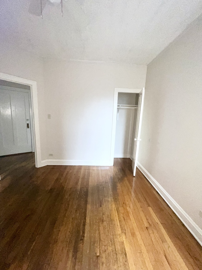 2140 North Kildare Avenue, Unit 2 Chicago, IL 60639 - Photo 6 of 11 a view of an empty room with wooden floor and a window