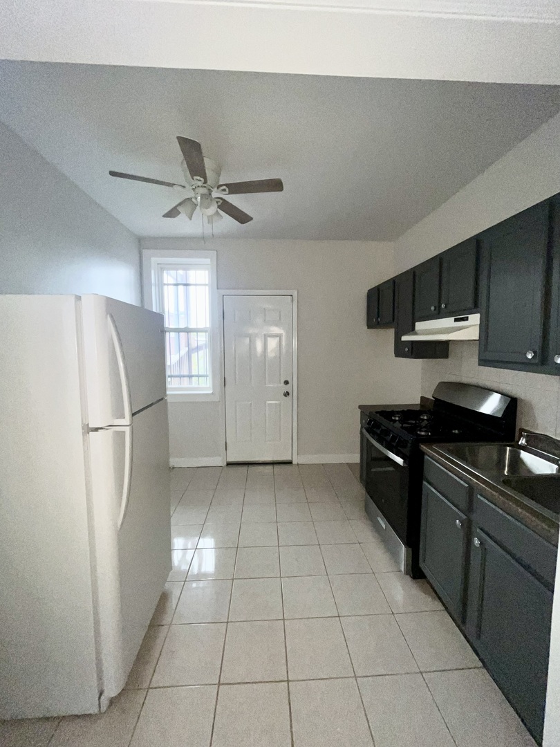 2140 North Kildare Avenue, Unit 2 Chicago, IL 60639 - Photo 9 of 11 a kitchen with stainless steel appliances granite countertop a refrigerator a sink a stove top oven and a refrigerator