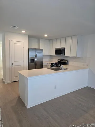 a kitchen with stainless steel appliances a refrigerator sink and microwave