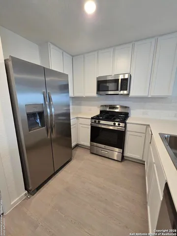 a kitchen with granite countertop a refrigerator and a sink