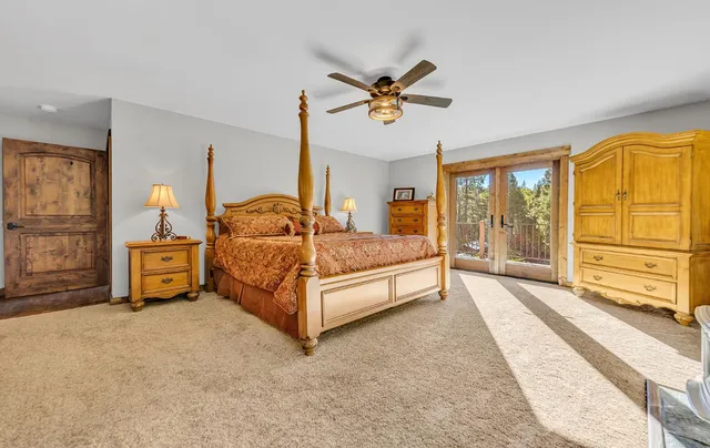 a bedroom with a bed and large windows