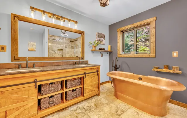 a bathroom with a tub a sink and a large mirror