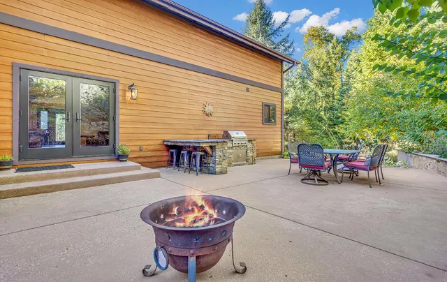 a backyard of a house with fire pit and chairs