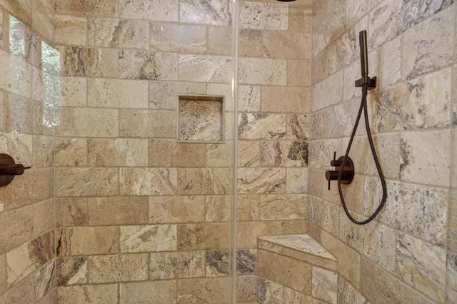 a bathroom with a granite countertop sink a toilet and shower