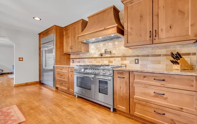 a kitchen with stainless steel appliances granite countertop a stove and a microwave
