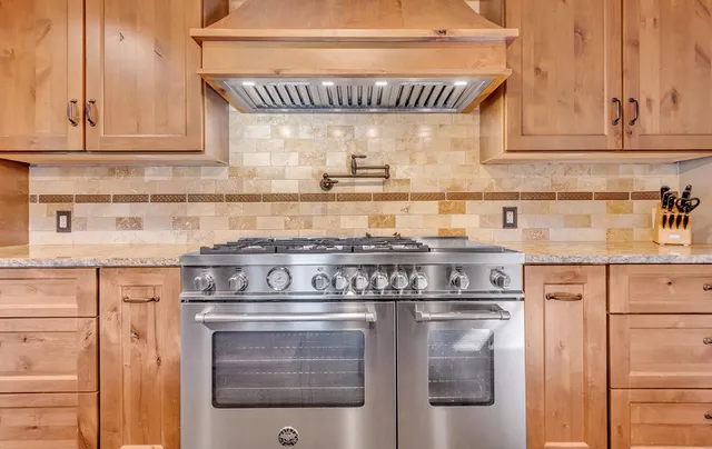 a kitchen with stainless steel appliances granite countertop a stove and cabinets