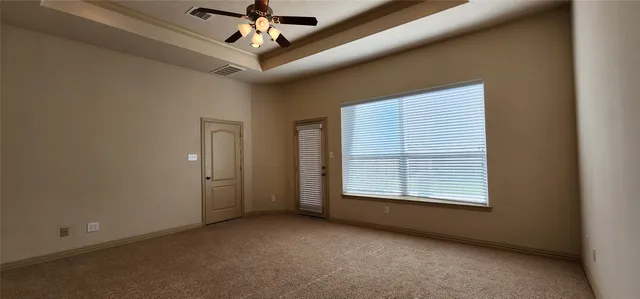 an empty room with windows and fan