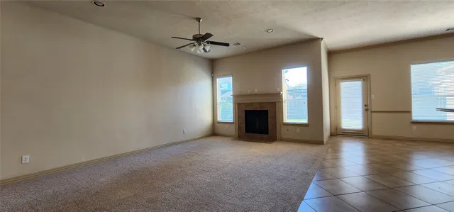 a view of an empty room with a fireplace and a window
