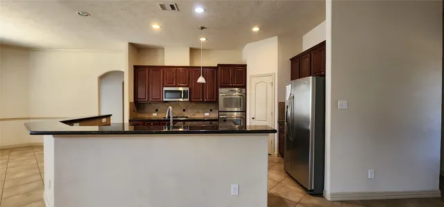 a kitchen with stainless steel appliances a sink refrigerator and microwave