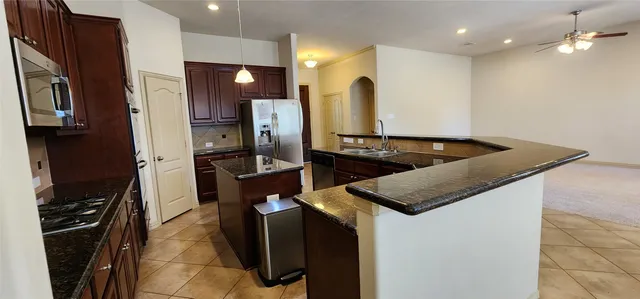 a kitchen with stainless steel appliances granite countertop a sink stove and refrigerator