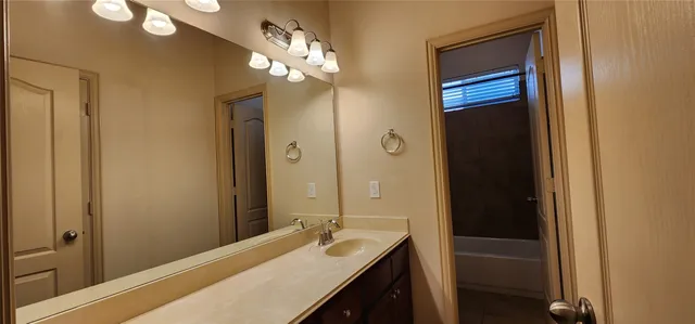 a bathroom with a granite countertop sink a mirror and a shower