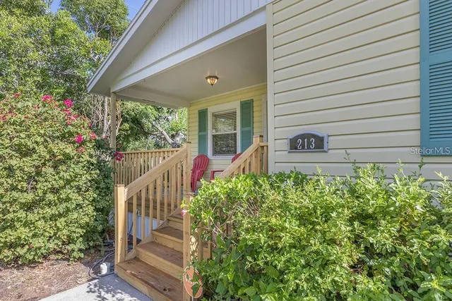 a view of a house with a small yard and a flower garden