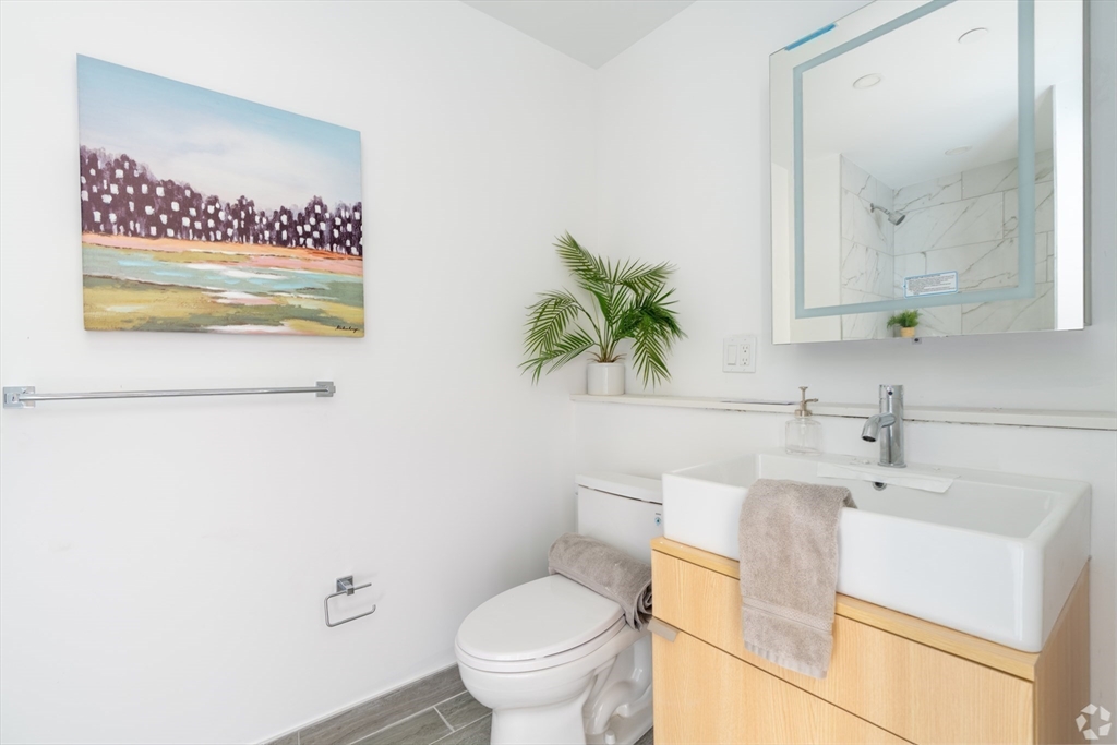 154 Broadway, Unit 409 Somerville, MA 02145 - Photo 11 of 18 a white toilet sitting next to a bathroom sink