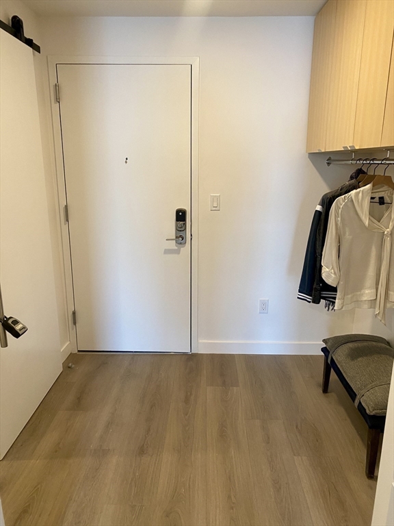 154 Broadway, Unit 409 Somerville, MA 02145 - Photo 8 of 18 a view of a room with wooden floor