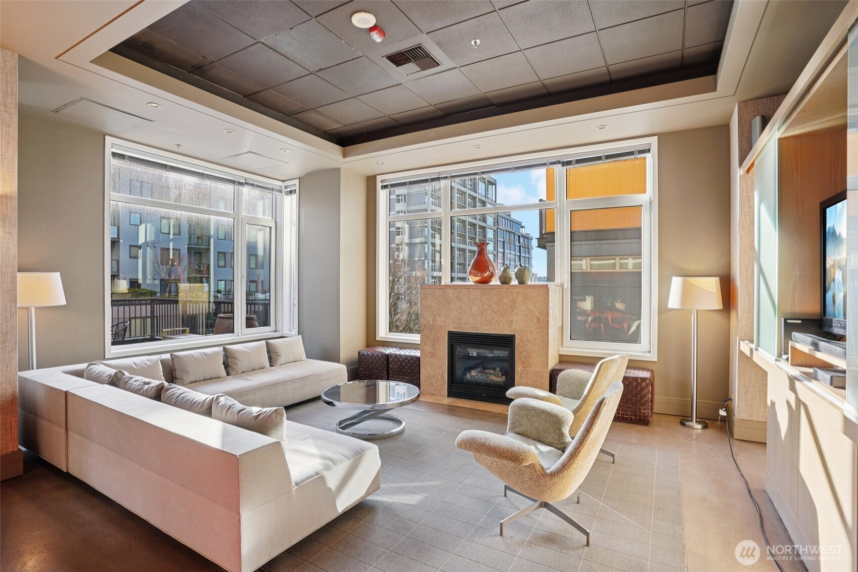 2801 1st Avenue, Unit 615 Seattle, WA 98121 - Photo 15 of 22 a living room with furniture a flat screen tv and a fireplace