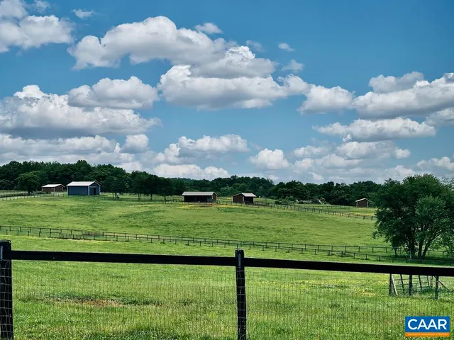 an aerial view of green landscape with trees houses and mountain view