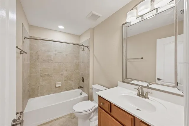 an empty room with wooden floor ceiling fan and windows