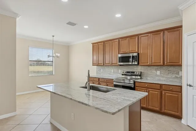 a kitchen with stainless steel appliances granite countertop a sink stove and cabinets