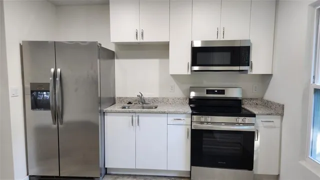 a kitchen with stainless steel appliances a stove a microwave and cabinets