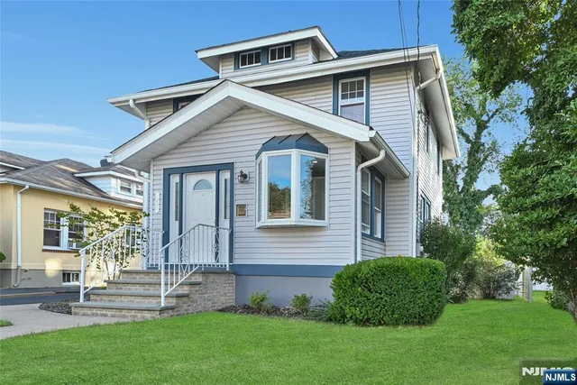 a front view of a house with a yard and green space