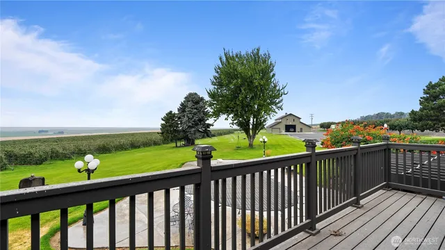 a view of a balcony with wooden floor & fence