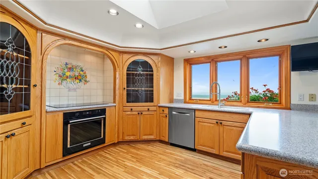 a view of a kitchen with stainless steel appliances granite countertop a stove and a wooden floor