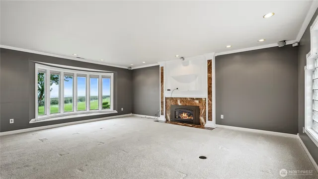 a view of an empty room with a fireplace and a window