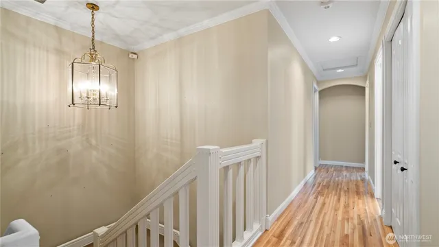 a view of a hallway with wooden floor and staircase