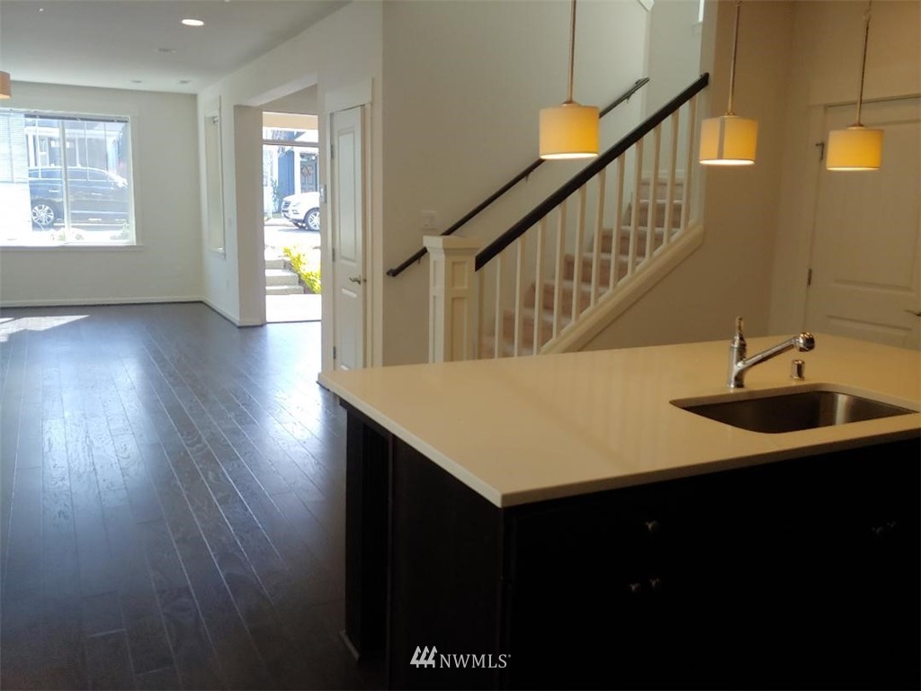 4422 185th Place Southeast Bothell, WA 98012 - Photo 3 of 28 a hallway with a sink a mirror and wooden floor